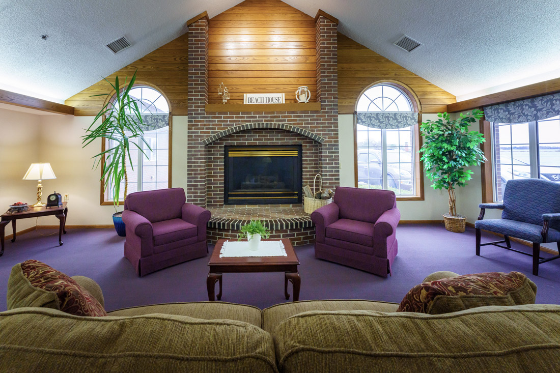Lake Pointe View lounge with a fireplace, large windows, and comfortable chairs.