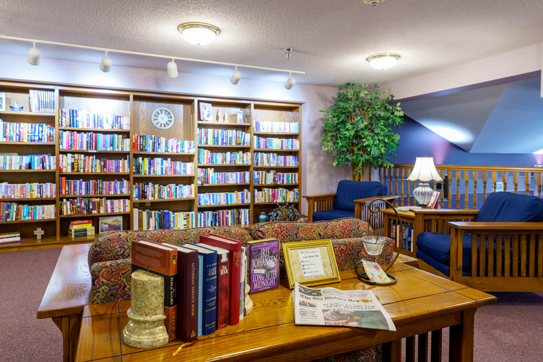Lake Pointe Villa library with large bookshelves and comfortable seating.