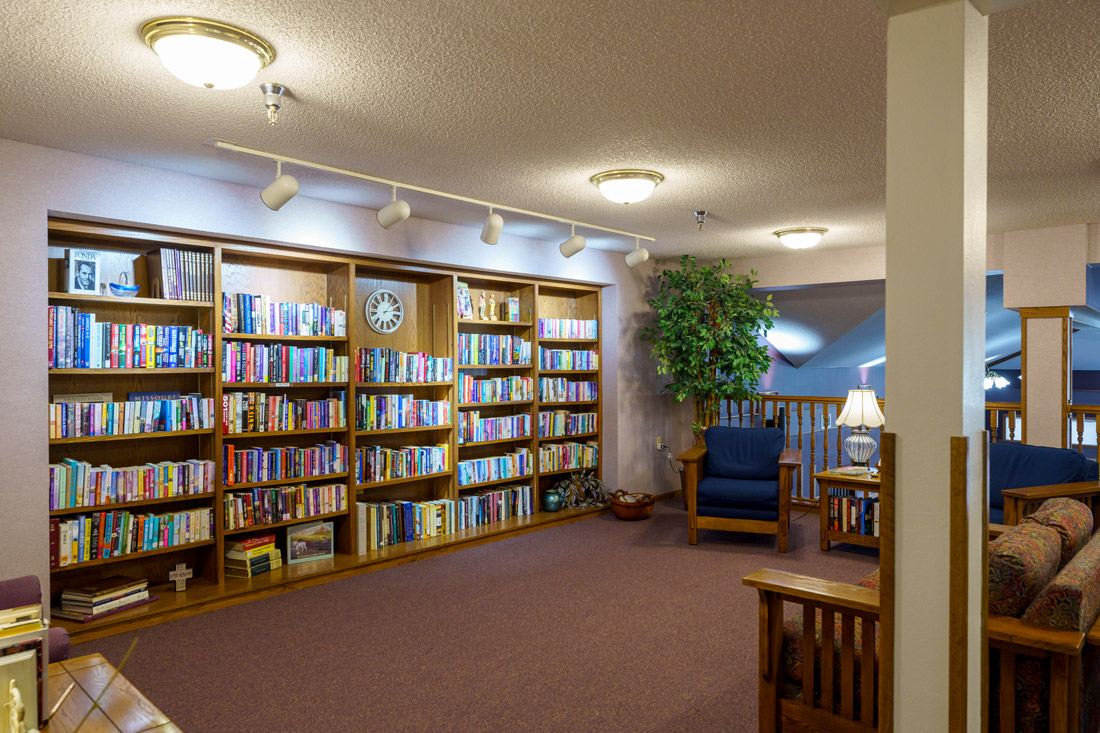 Lake Pointe Villa library with large bookshelves and comfortable chairs.