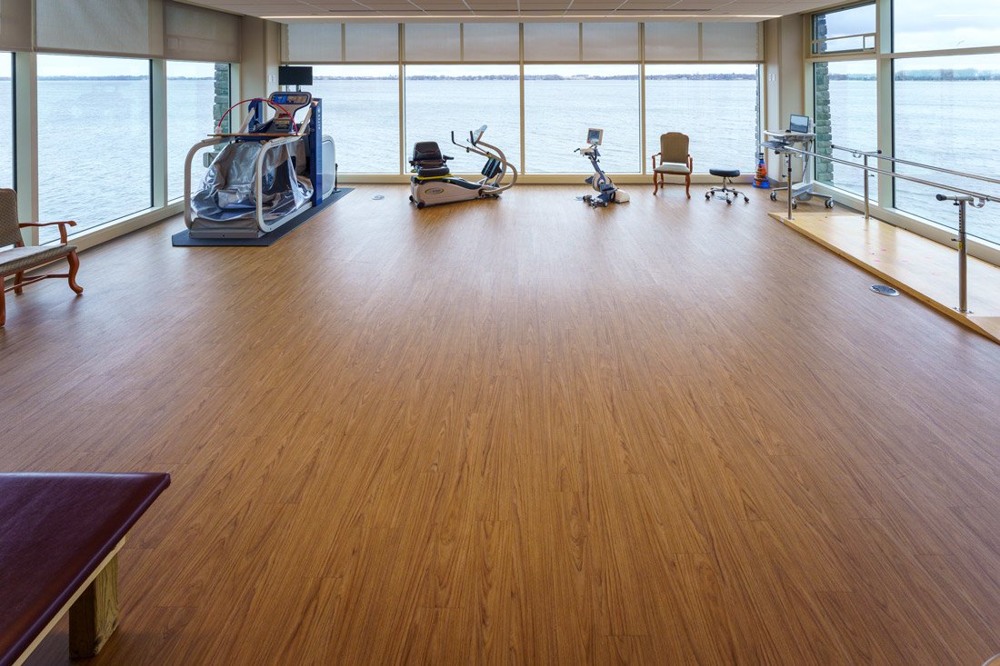 Bayside View rehabilitation room showing exercise equipment, and large windows with a view of Storm Lake.