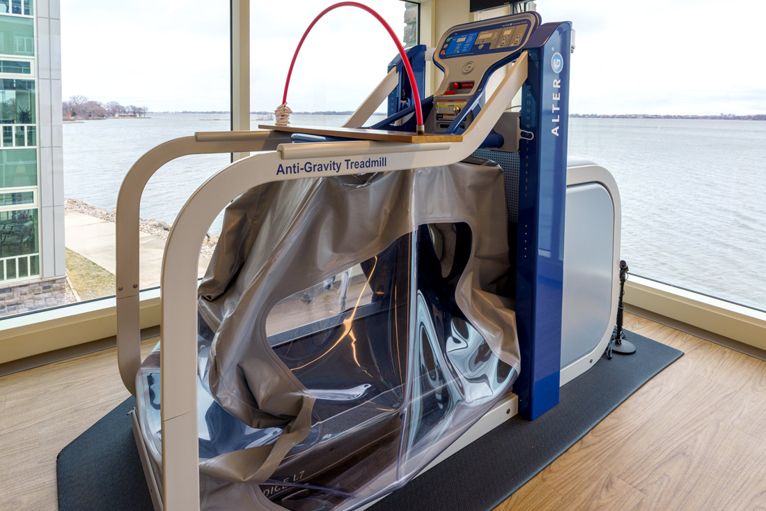 Bayside View rehabilitation room showing an anti-gravity treadmill, and large windows with a view of Storm Lake.